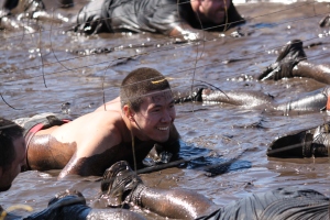 Jeff crawling through mud under barbed wire at the Tough Mudder last summer
